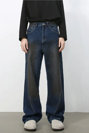 Faded panel wide-leg denim trousers in medium wash with a relaxed fit.