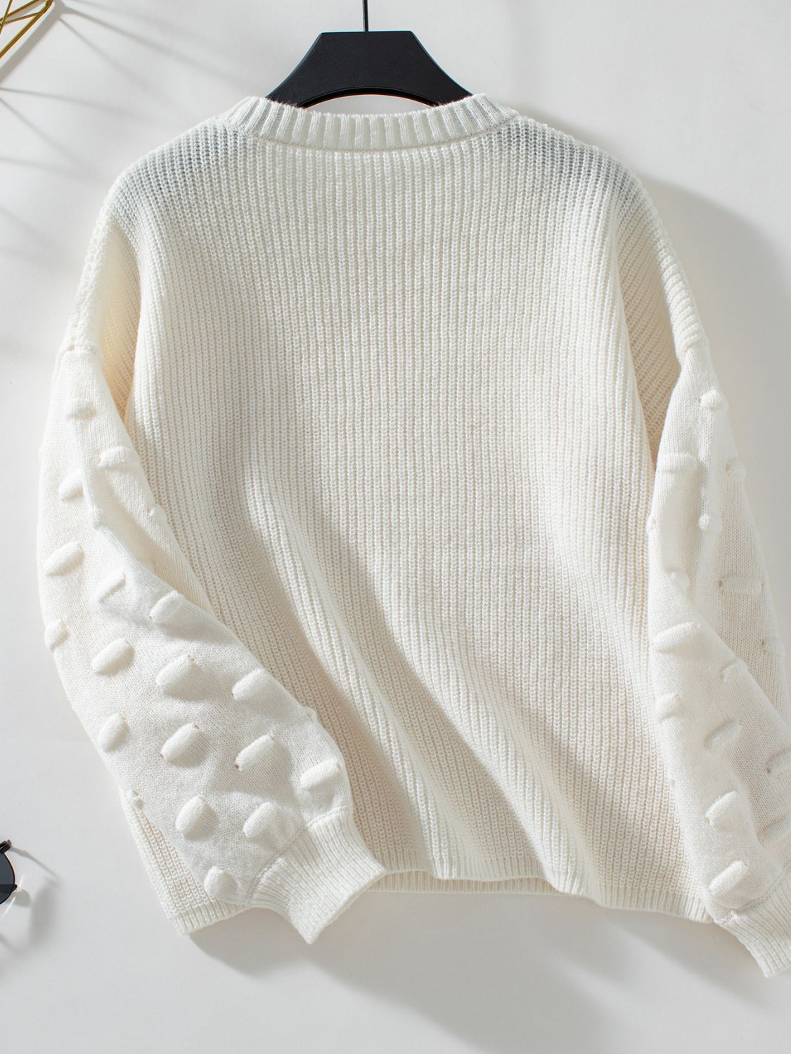 Ivory knit sweater with textured dot sleeves and crew neck.