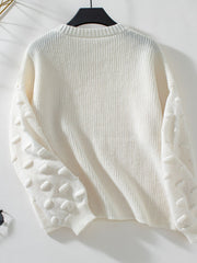 Ivory knit sweater with textured dot sleeves and crew neck.