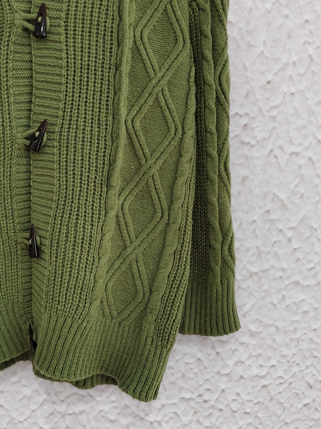Moss green cable knit hoodie with toggle buttons and diamond pattern details.