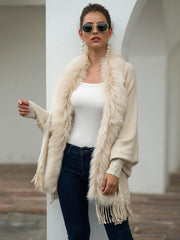 Ivory faux fur trimmed fringe cape with long sleeves and a draped silhouette.