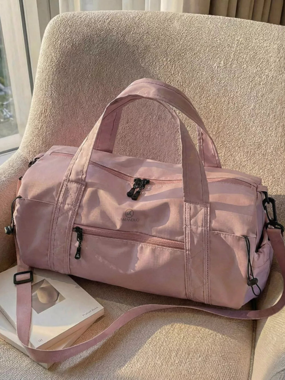 Pink nylon travel organizer bag with multiple zippered pockets and adjustable strap.
