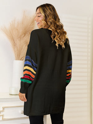 Black acrylic knit cardigan with rainbow striped sleeves.