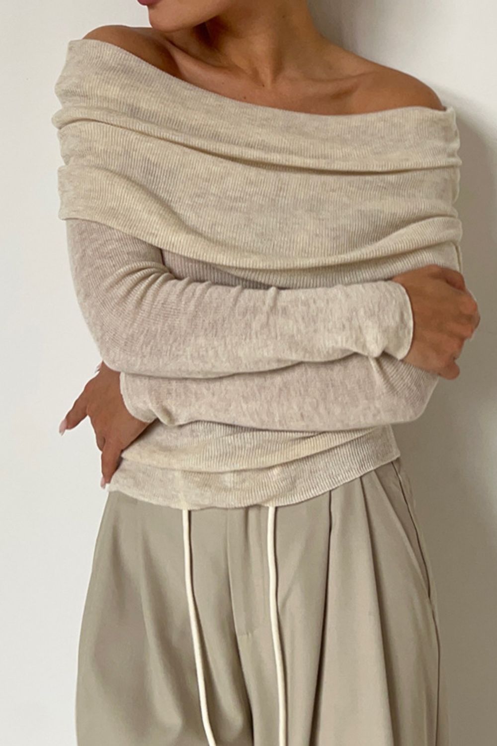 Off-the-shoulder ribbed knit top in khaki with draped neckline and long sleeves.