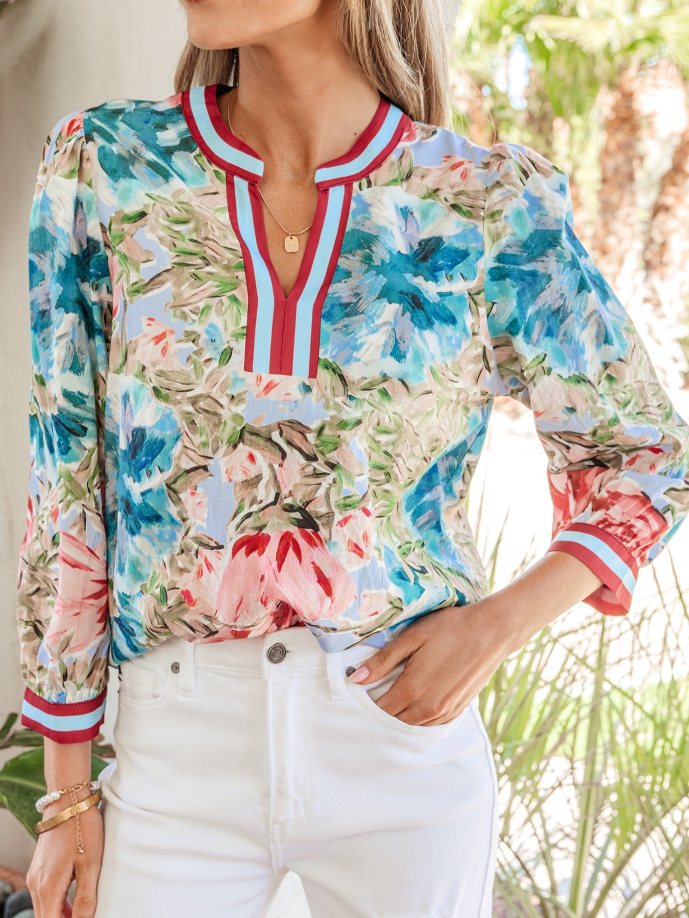 Women's cotton V-neck blouse with abstract floral print and striped trim.