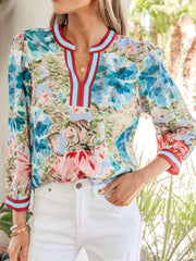 Women's cotton V-neck blouse with abstract floral print and striped trim.