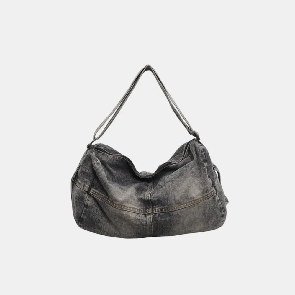 Washed denim hobo bag in medium grey with a slouchy silhouette and adjustable strap.