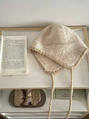 Wool-blend hat with ear flaps in ivory, featuring braided ties and contrast trim.