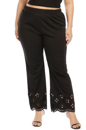 Black flare trousers with floral cutouts at the hemline.