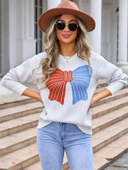 Graphic bow knit sweater in ivory with red and blue bow detail.