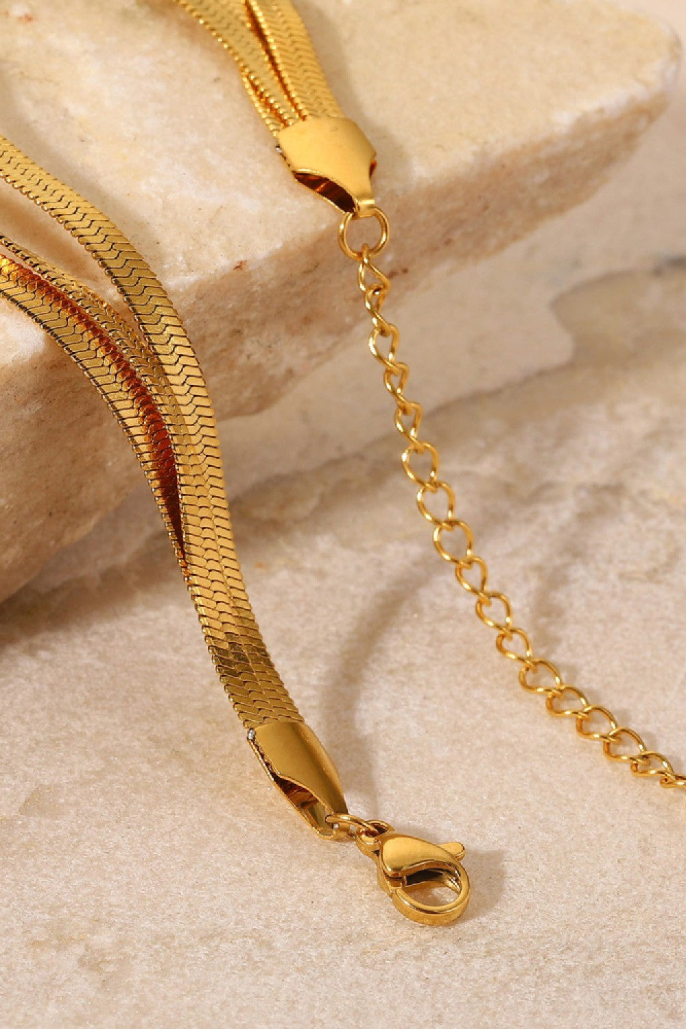 Gold triple herringbone chain bracelet with lobster clasp and extender chain.