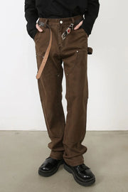 Brown carpenter pants with utility pockets and a relaxed fit.