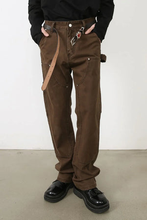 Brown carpenter pants with utility pockets and a relaxed fit.