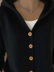 Black button-front hooded knit cardigan with wooden buttons, worn over a white tank top.