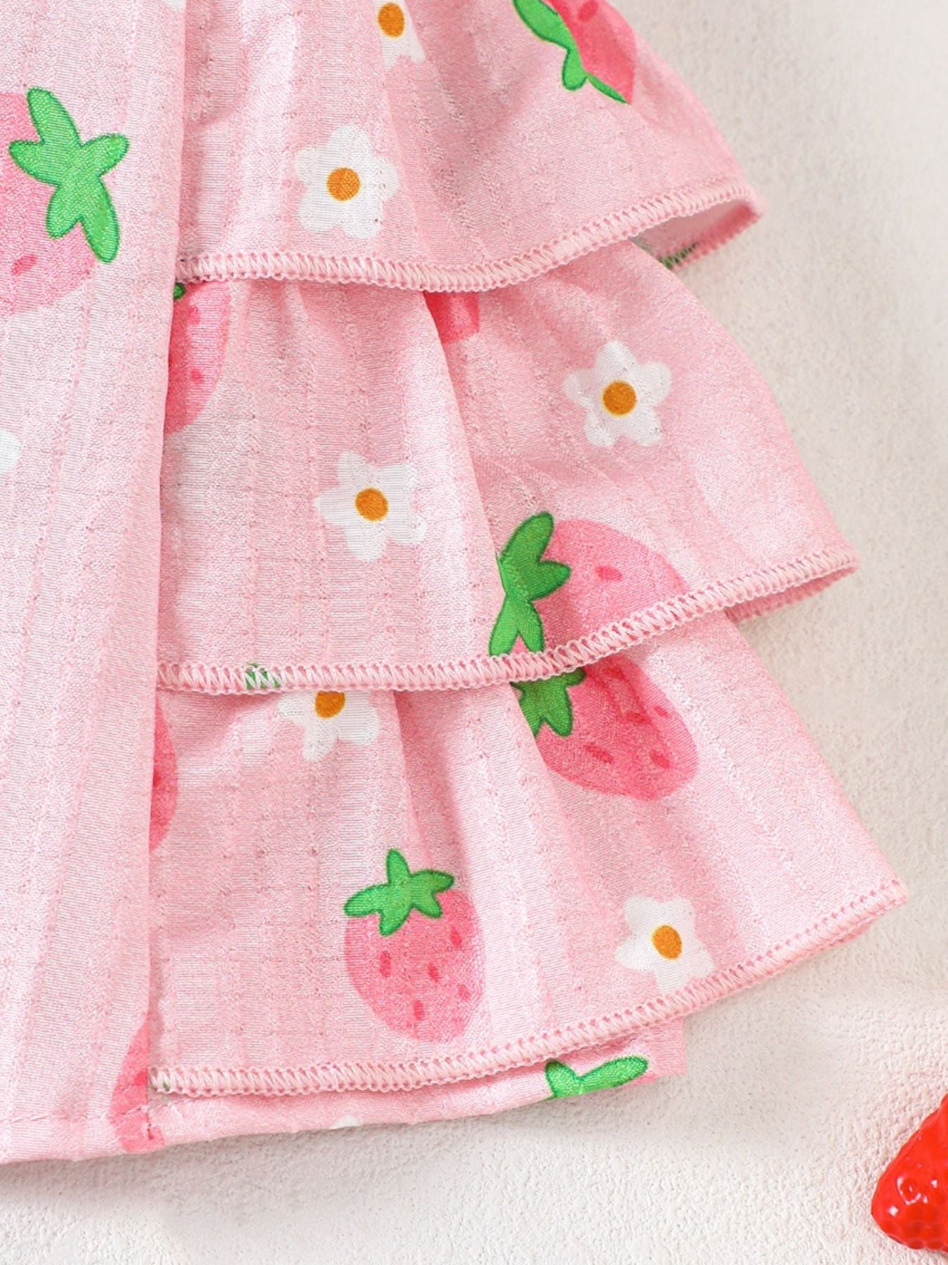 Pink cotton cami set with strawberry and flower print, featuring tiered ruffles.