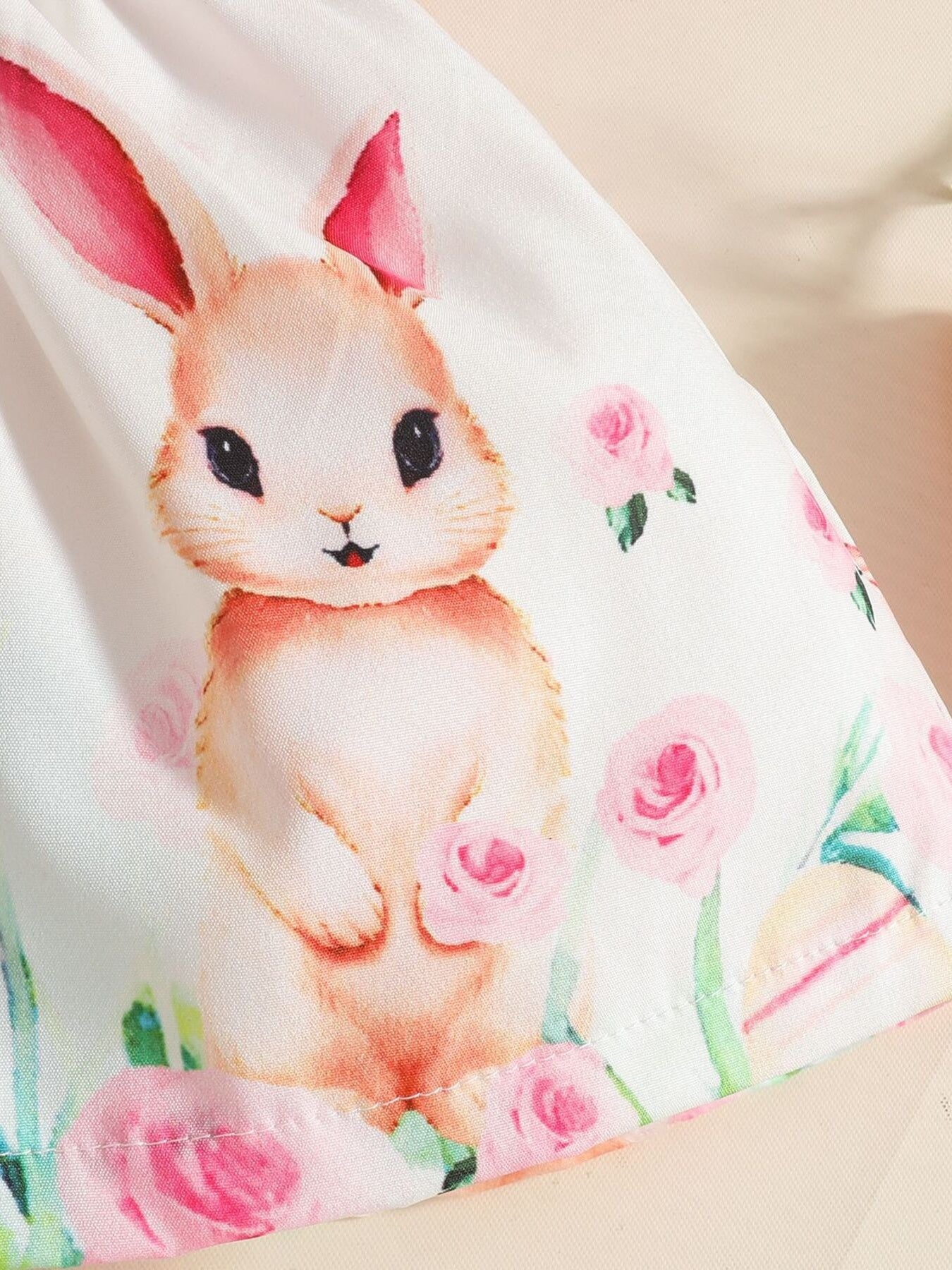 Baby dress with bunny and pink rose print, ruffled hem detail