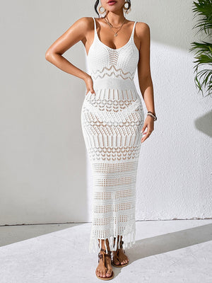 White crochet maxi dress with fringe hem and intricate knit patterns.