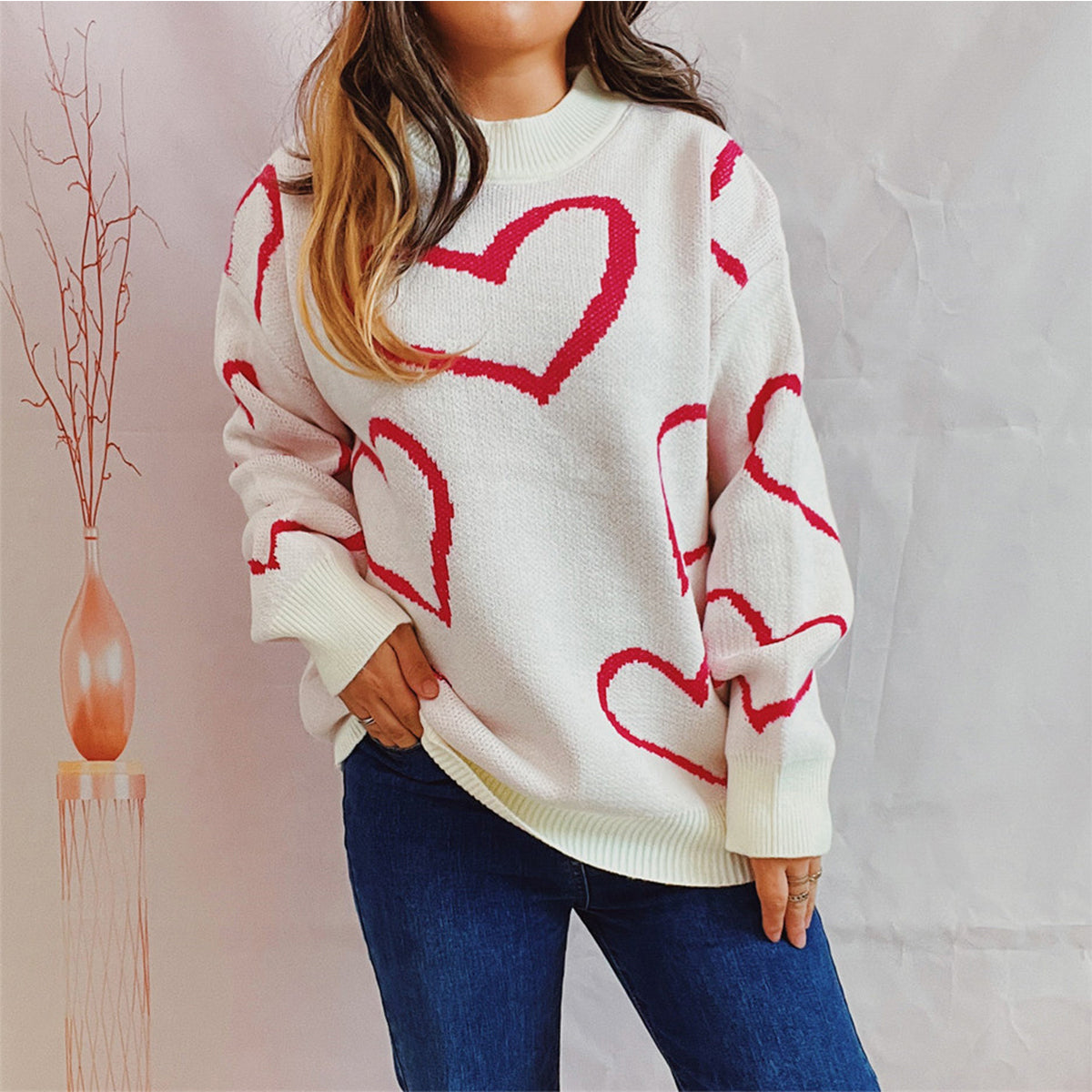 White knit sweater with red heart pattern, crew neck, long sleeves.