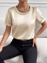 Pearl-trimmed satin bodysuit with short puff sleeves and a round neckline.