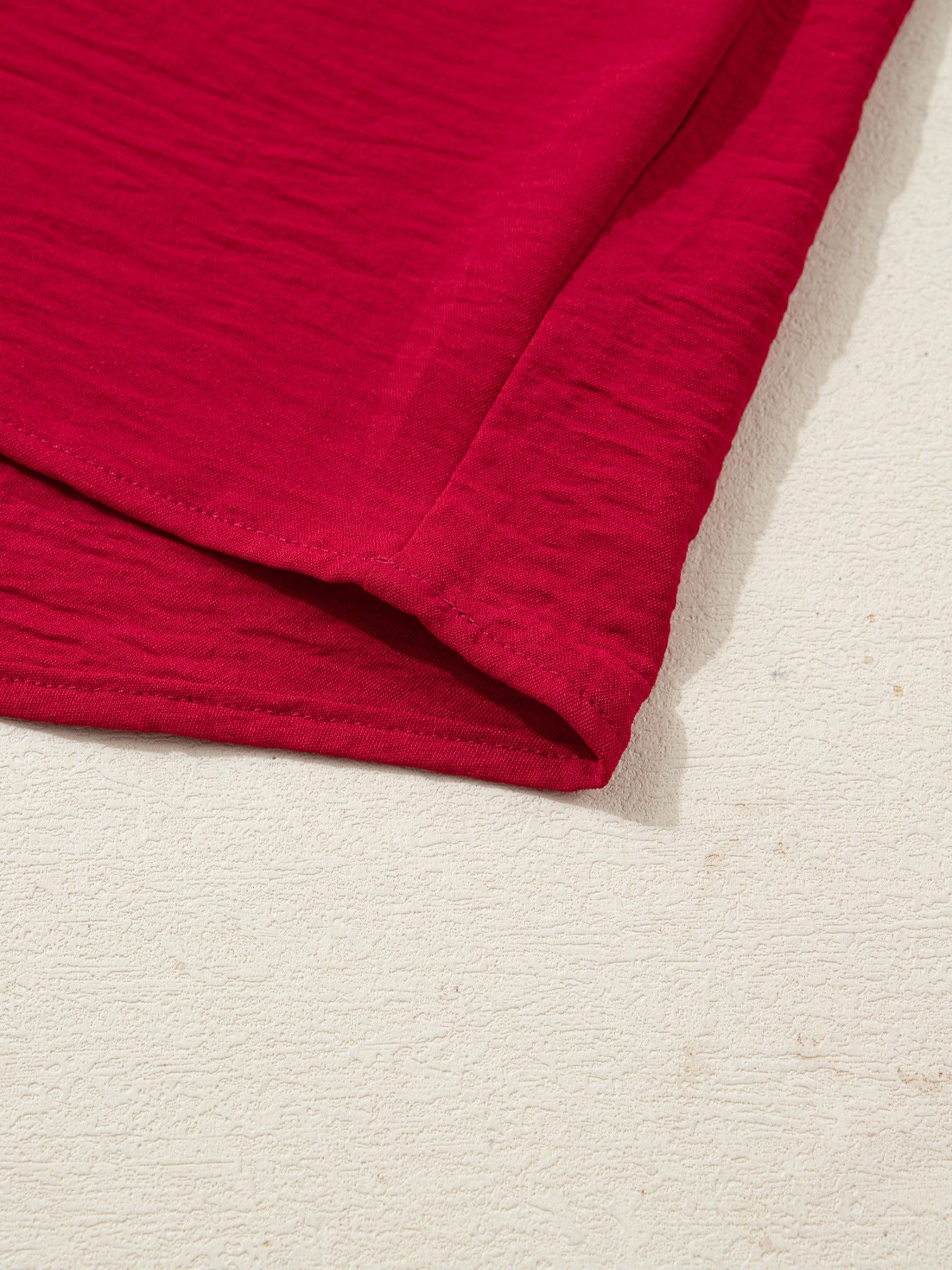 Deep red braided V-neck blouse with textured fabric and half sleeves.