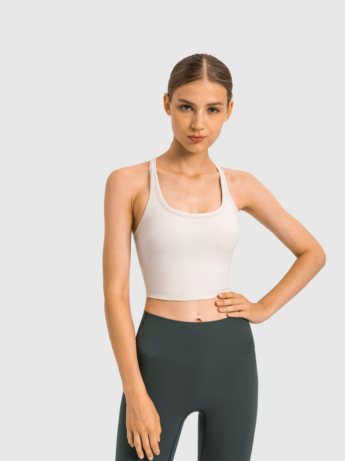 Sculpted racerback crop tank in beige with a scoop neckline and thin straps.