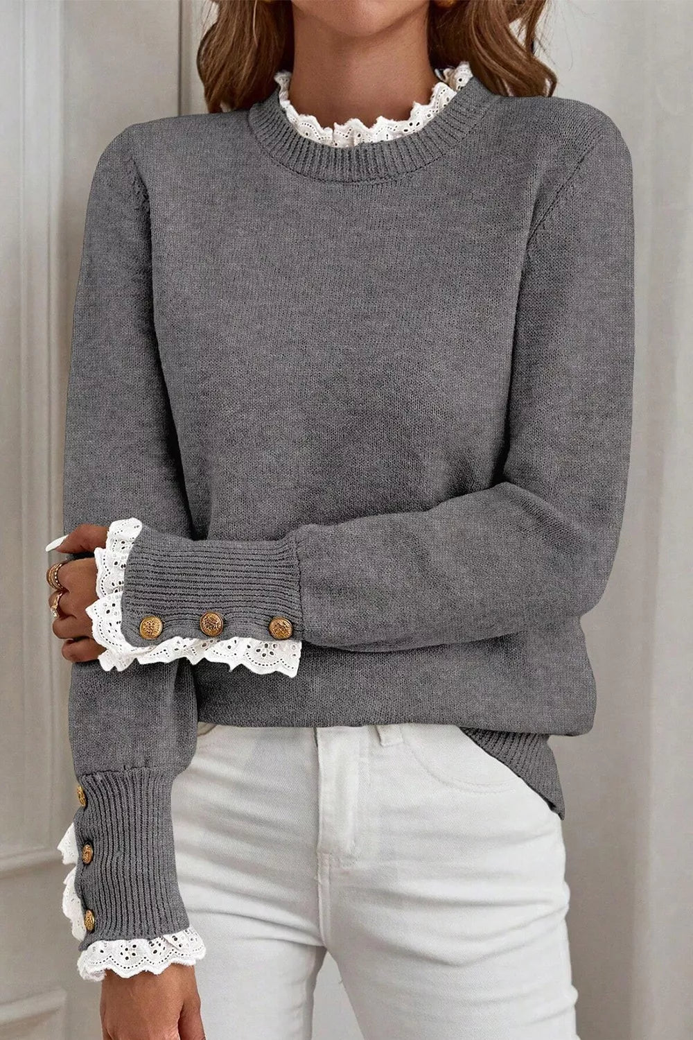 Dark gray knit sweater with mock neck and lace trim cuffs with buttons.