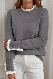 Dark gray knit sweater with mock neck and lace trim cuffs with buttons.