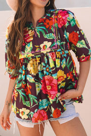 Embroidered floral babydoll blouse with split neck and puff sleeves.