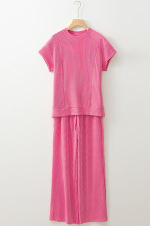 Fuchsia pink ribbed knit drawstring co-ord set with short sleeves and wide leg pants.