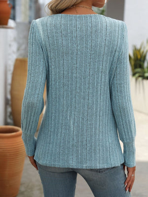 Pastel blue ribbed knit top with side button detail, long sleeves, and a relaxed fit.
