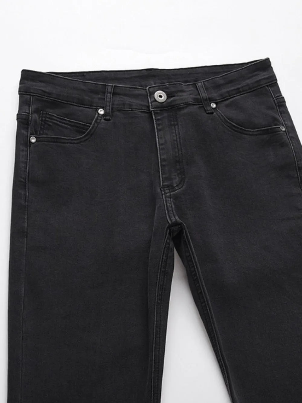 Black wash jeans with split hem detail and classic five-pocket styling.