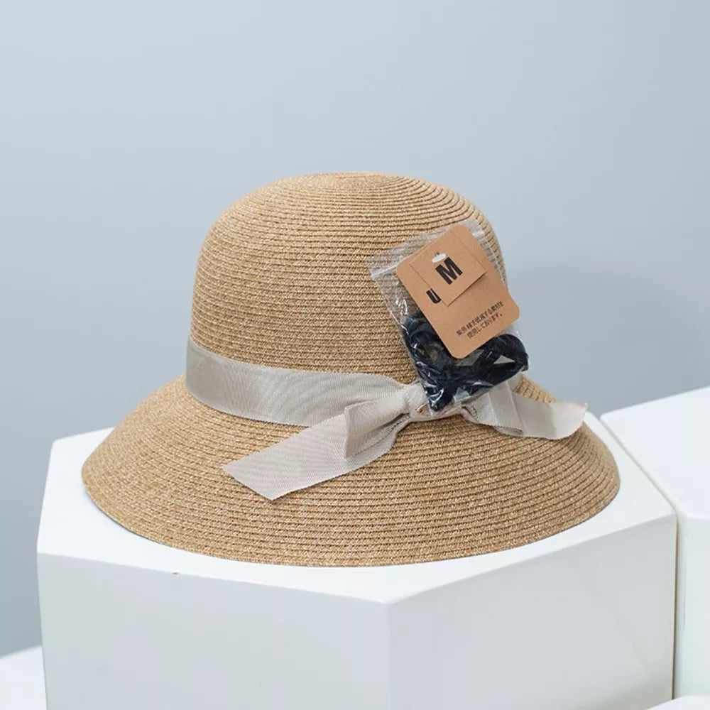Straw bucket hat in Dust Storm with downturned brim and ribbon detail.
