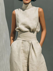 Sleeveless mock-neck ivory top and wide-leg pants set with belted waist and pleats