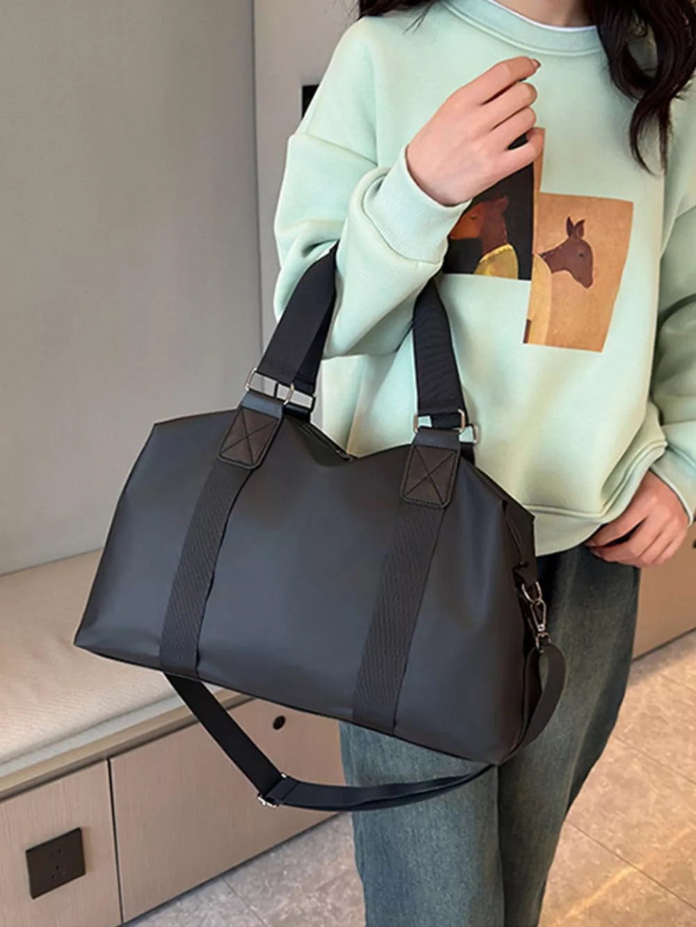 Sleek black Oxford cloth travel duffel bag with adjustable strap and top handles.