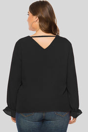 Black V-neck blouse with long sleeves and cutout detail at back neckline.