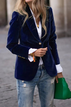 Navy velvet blazer with gold button detail and notched lapels, worn open over a white shirt.