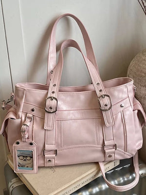 Pink shoulder bag with buckle details and a cute charm