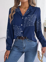 Dark blue collared blouse with white script pattern, button front, and long sleeves.