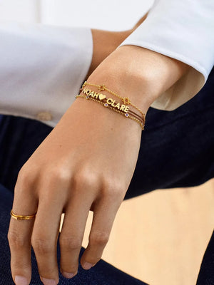Gold charm bracelets with names Noah and Clare, heart, and star charms