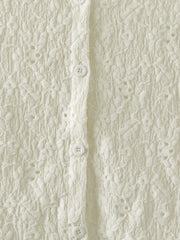 Cream lace button-up cardigan with floral texture and white buttons.