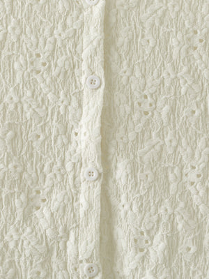 Cream lace button-up cardigan with floral texture and white buttons.