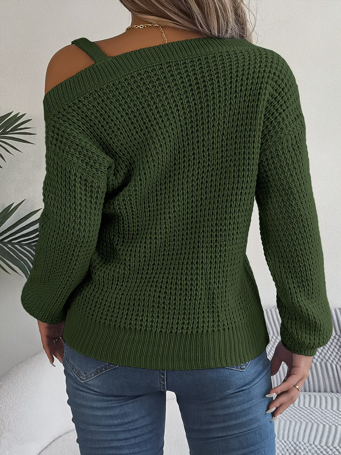 Army green one-shoulder knit sweater with buckle detail and waffle texture.