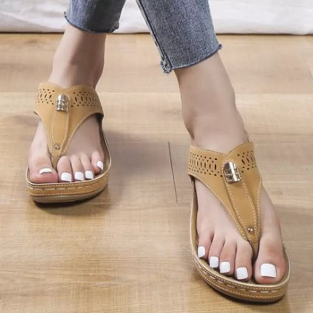 Khaki perforated leather wedge sandals with thong strap and gold buckle detail.