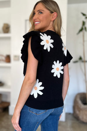Black knit blouse with white daisy print and ruffled short sleeves