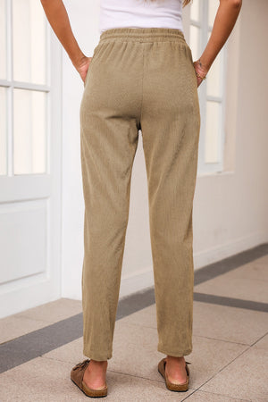 Khaki corduroy drawstring trousers with slant pockets and a relaxed fit.