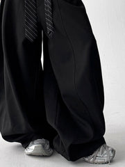 Men's black wide leg sweatpants with drawstring and striped tie detail.