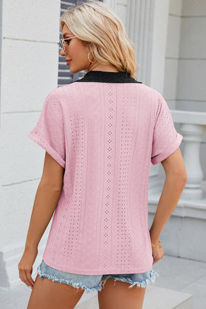 Blush pink perforated polo top with short sleeves and black collar detail.