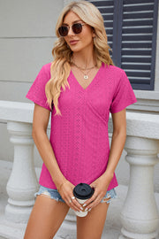 Eyelet wrap V-neck top in hot pink with short sleeves and a textured pattern.