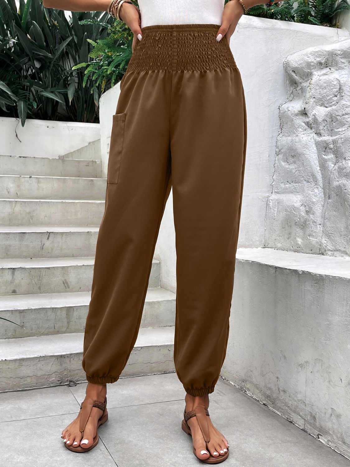 Brown relaxed-fit cargo pants with smocked waist and elastic cuffs.