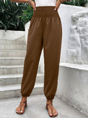 Brown relaxed-fit cargo pants with smocked waist and elastic cuffs.